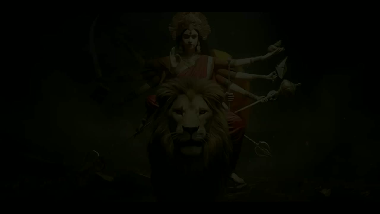 An idol of Durga upon her lion, low light, at a Kolkata Durga Puja pandal.